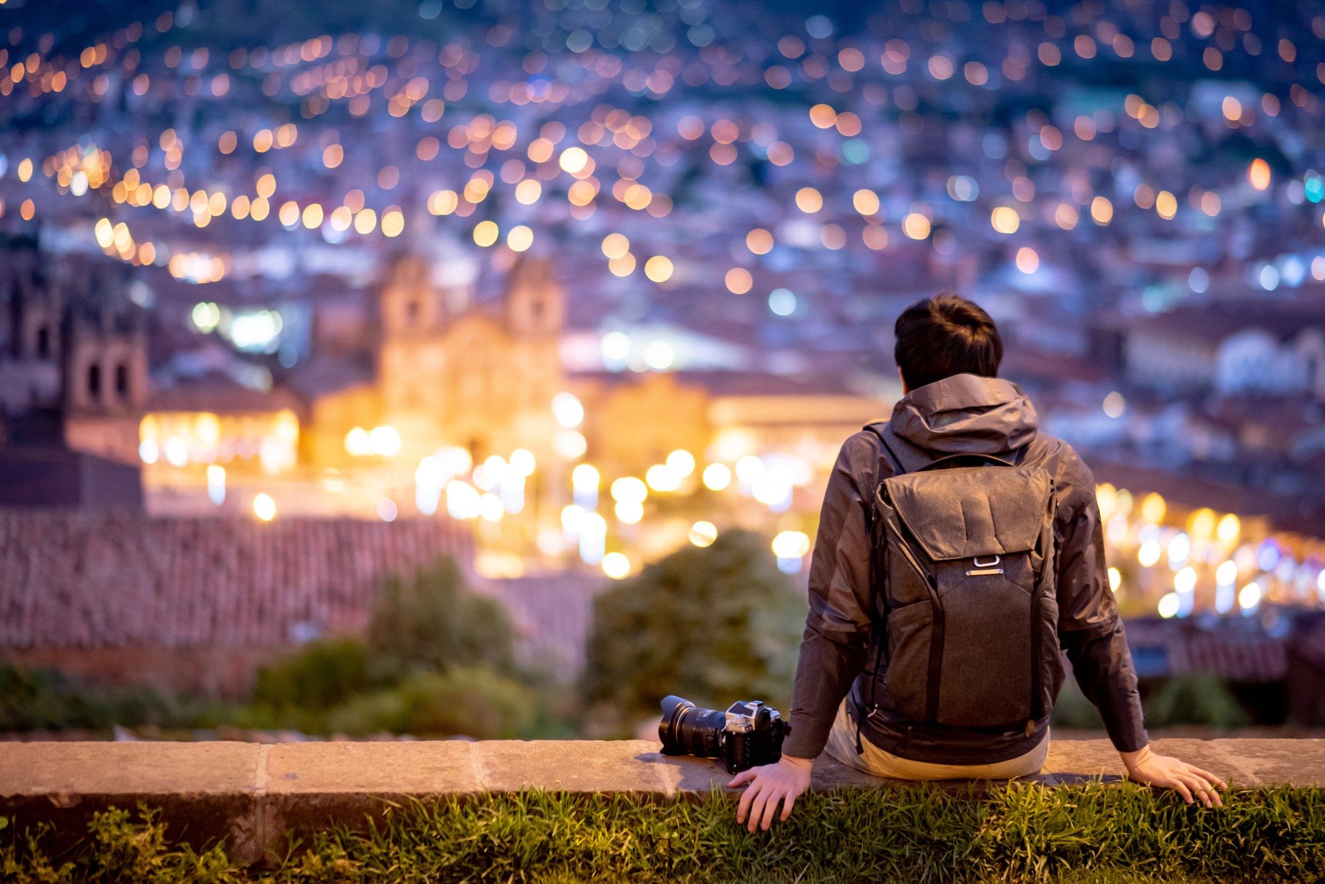 Asian man traveler looking at Cusco city at night